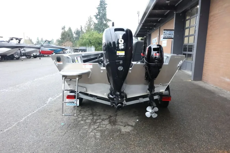Slide: The Image of 2025 Thunder Jet 209 Rush OT boat with dual outboard motors, parked outside a building. - 7