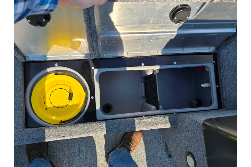 Slide: The Image of 2020 Tracker Pro Guide V-16 SC boat storage compartments with yellow bucket and gray container. - 16