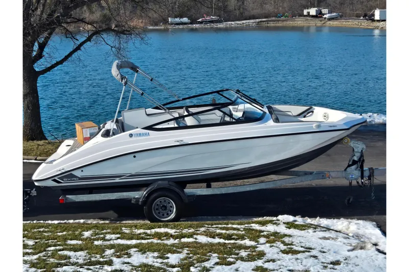 The Image of 2020 Yamaha Boats SX190 on trailer by a lake in winter setting. - 0