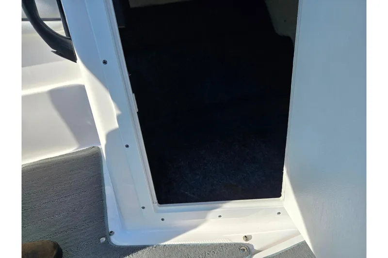 Slide: The Image of 2020 Yamaha Boats SX190 interior hatch, showcasing entryway and carpeted flooring. - 15