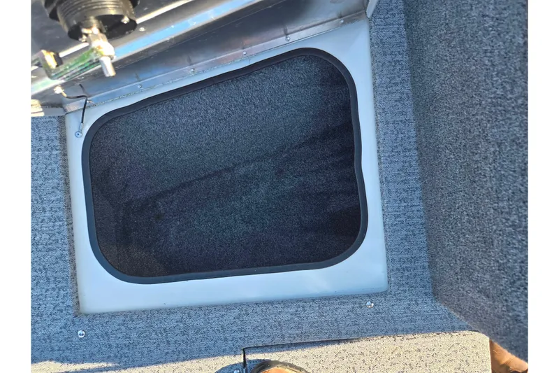 Slide: The Image of 2021 Tracker Pro Guide V-165 WT boat interior storage compartment with gray carpeting. - 19