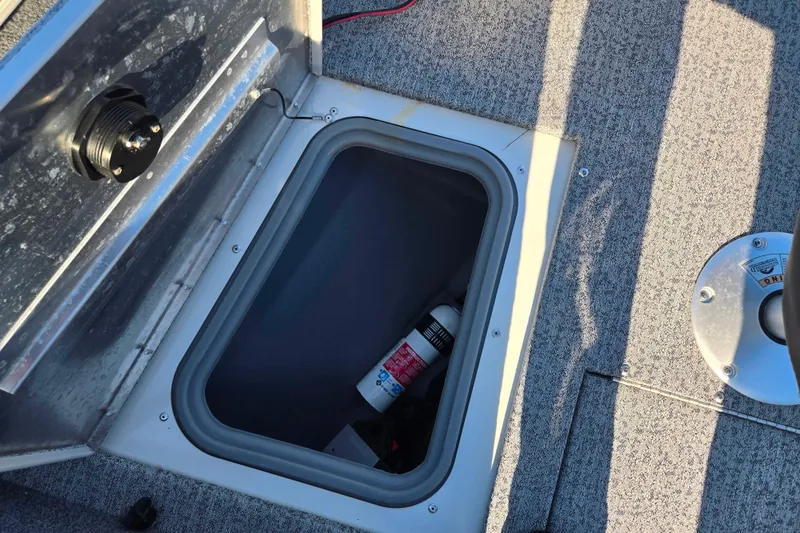 Slide: The Image of 2021 Tracker Pro Guide V-165 WT boat storage compartment with fire extinguisher. - 20