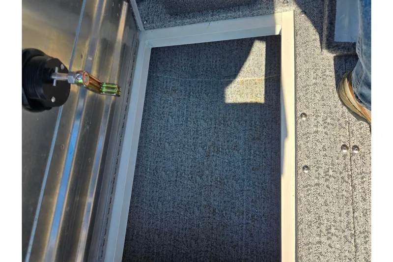 Slide: The Image of 2021 Tracker Pro Guide V-165 WT boat interior with carpeted flooring and storage compartment. - 24