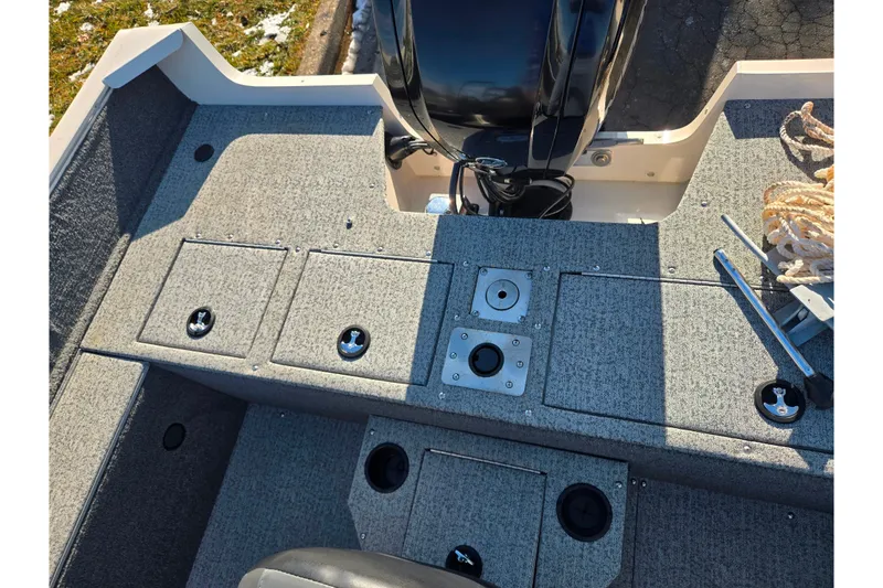 Slide: The Image of 2021 Tracker Pro Guide V-165 WT boat interior with storage compartments and motor. - 28