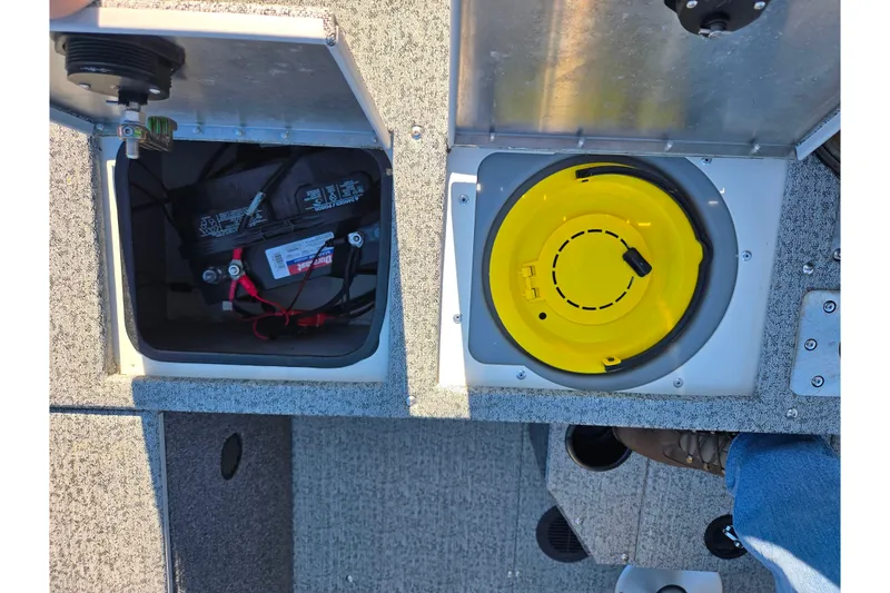 Slide: The Image of 2021 Tracker Pro Guide V-165 WT boat compartments with battery and yellow storage. - 30