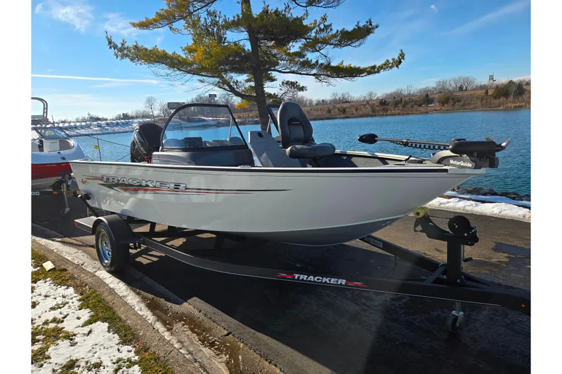 Slide: The Image of 2021 Tracker Pro Guide V-165 WT boat on trailer by a lake. - 9