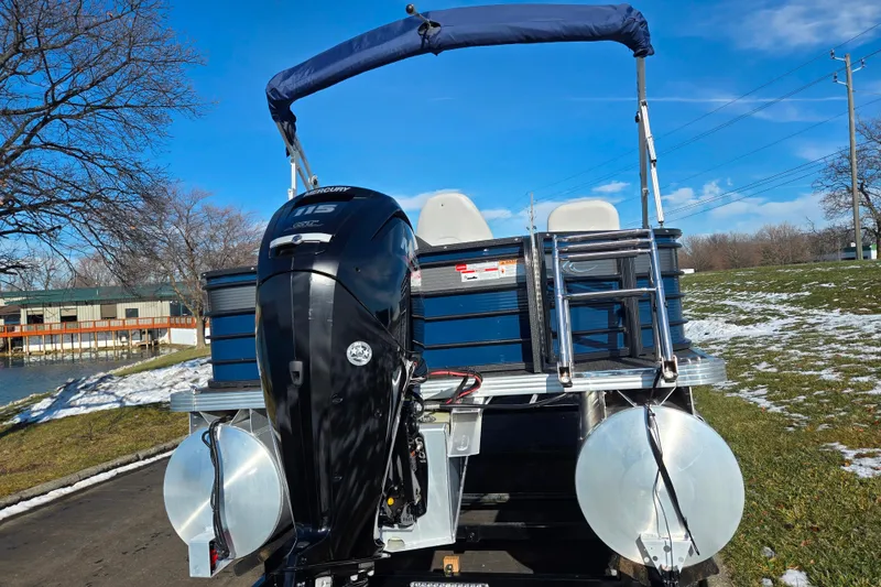 Slide: The Image of 2022 Crest Classic Fish 200 pontoon boat with Mercury 115 outboard motor, parked on snowy grass. - 2