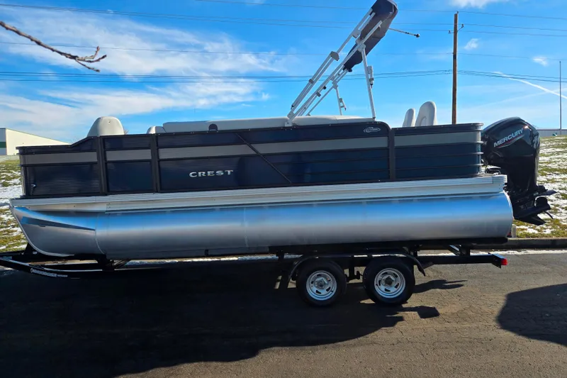 Slide: The Image of 2022 Crest Classic Fish 200 pontoon boat on trailer, side view. - 4