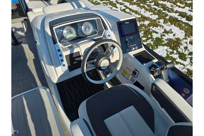 Slide: The Image of 2023 Barletta Corsa 23UC boat dashboard with steering wheel and control panel. - 14