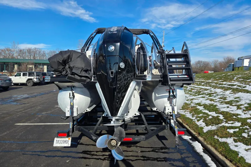 Slide: The Image of 2023 Barletta Corsa 23UC pontoon boat on trailer, rear view, in parking lot. - 2