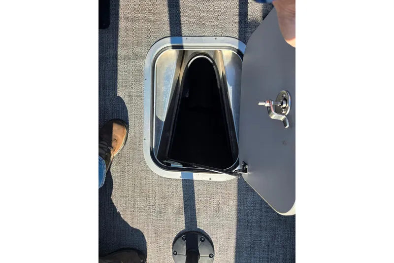 Slide: The Image of 2023 Barletta Corsa 23UC boat storage compartment with open hatch on textured flooring. - 21