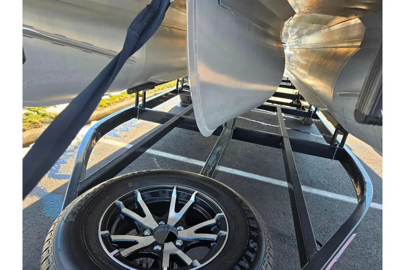 Slide: The Image of Underneath view of 2023 Barletta Corsa 23UC pontoon boat on trailer with visible wheel. - 7