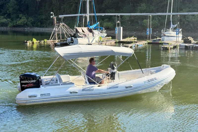 Slide: The Image of A 2005 Caribe DL20 boat with a Mercury engine on a calm river. - 3