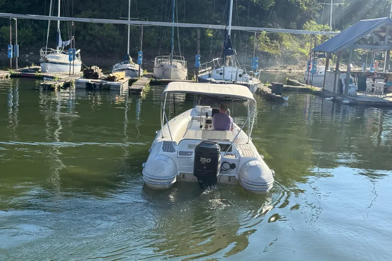 Slide: The Image of Boat navigating marina with sailboats and dock, featuring Caribe DL20, 2005 model. - 5
