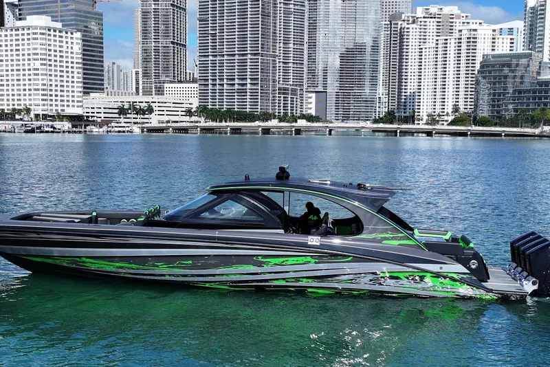 The Image of 2026 Mystic Powerboats M5200 XL Cabin on water with city skyline backdrop. - 0