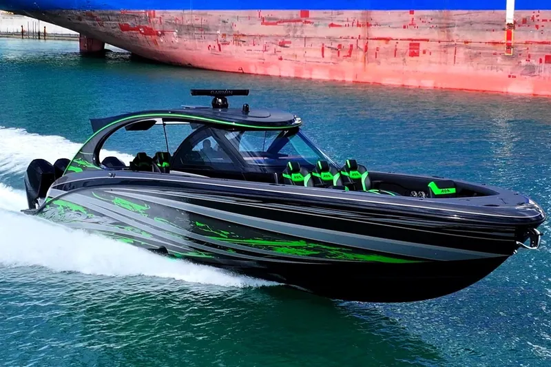 Slide: The Image of 2026 Mystic Powerboats M5200 XL Cabin cruising near a large cargo ship in a city harbor. - 10