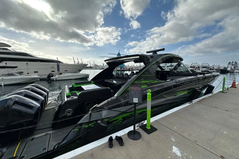 Slide: The Image of 2026 Mystic Powerboats M5200 XL Cabin docked at marina under cloudy sky. - 11