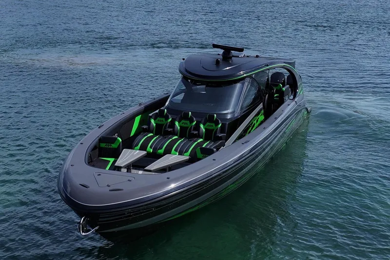 Slide: The Image of 2026 Mystic Powerboats M5200 XL Cabin cruising on a calm, scenic waterway. - 2