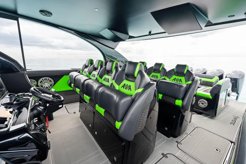 Slide: The Image of 2026 Mystic Powerboats M5200 XL Cabin interior with sleek black and green seating. - 21