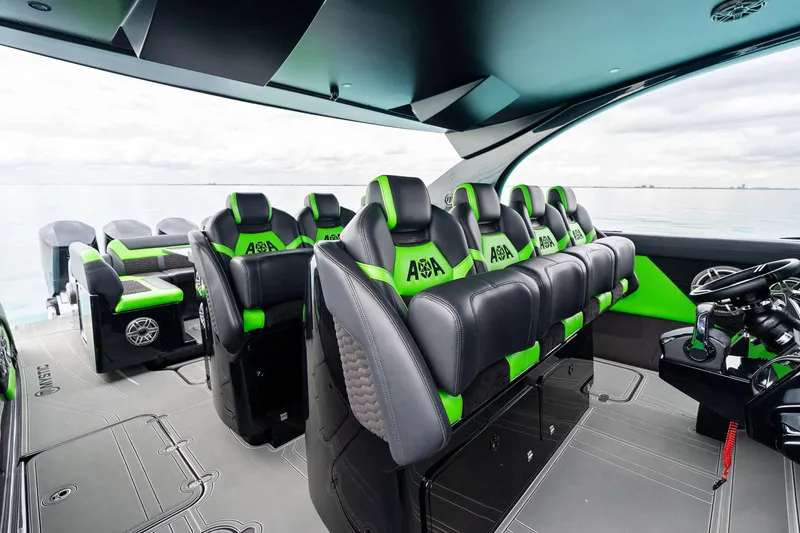 Slide: The Image of 2026 Mystic Powerboats M5200 XL Cabin interior with sleek black and green seating. - 22