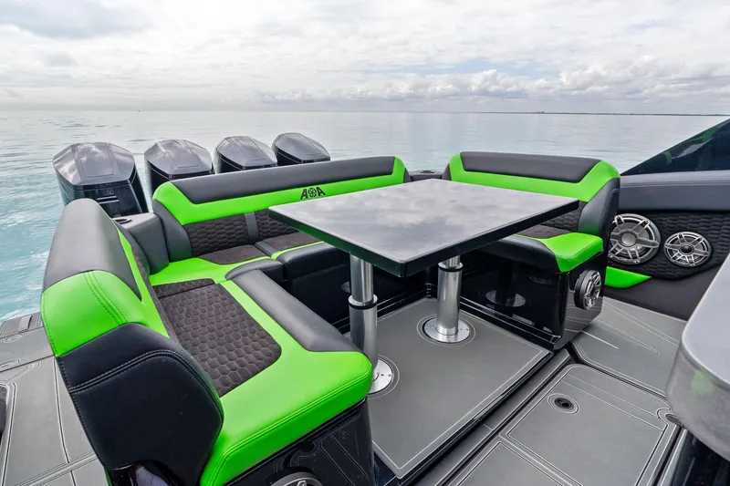 Slide: The Image of 2026 Mystic Powerboats M5200 XL Cabin with vibrant green seating and sleek table design. - 25