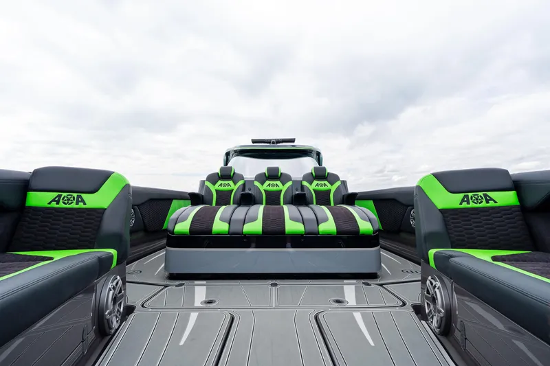 Slide: The Image of 2026 Mystic Powerboats M5200 XL Cabin with sleek green and black seating design. - 31