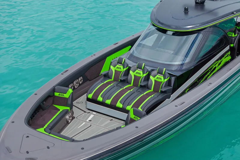 Slide: The Image of 2026 Mystic Powerboats M5200 XL Cabin with vibrant green and black seating on turquoise water. - 33