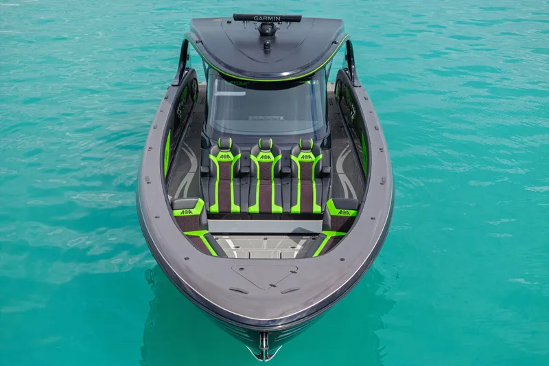 Slide: The Image of 2026 Mystic Powerboats M5200 XL Cabin on turquoise water, featuring sleek design and vibrant seating. - 34