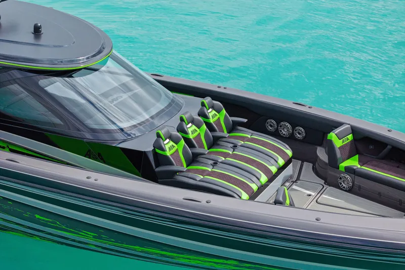 Slide: The Image of 2026 Mystic Powerboats M5200 XL Cabin with sleek design and vibrant green accents on turquoise water. - 35