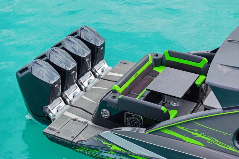 Slide: The Image of 2026 Mystic Powerboats M5200 XL Cabin with quad engines and vibrant seating on turquoise water. - 36