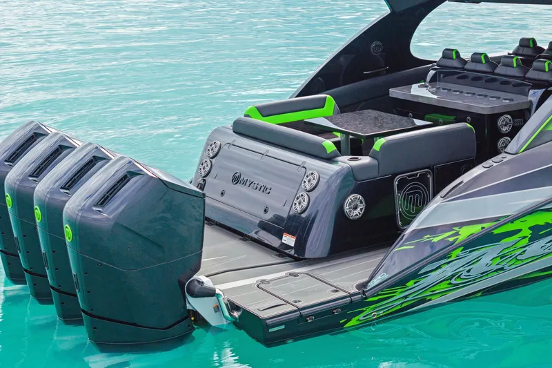 Slide: The Image of 2026 Mystic Powerboats M5200 XL Cabin with four powerful engines on turquoise water. - 37