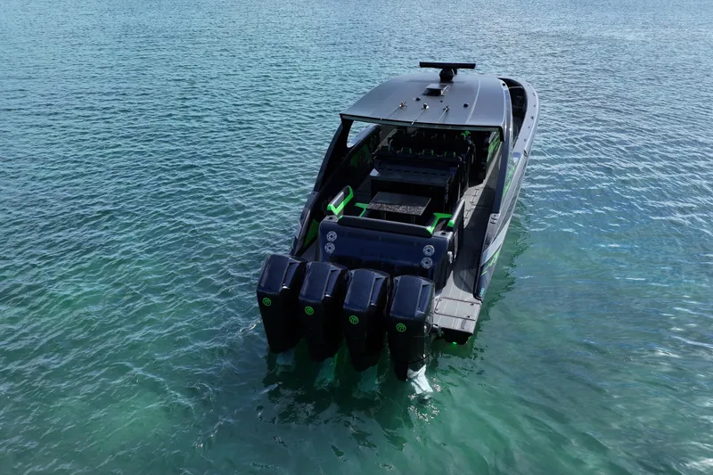 Slide: The Image of 2026 Mystic Powerboats M5200 XL Cabin on clear blue water, rear view. - 5