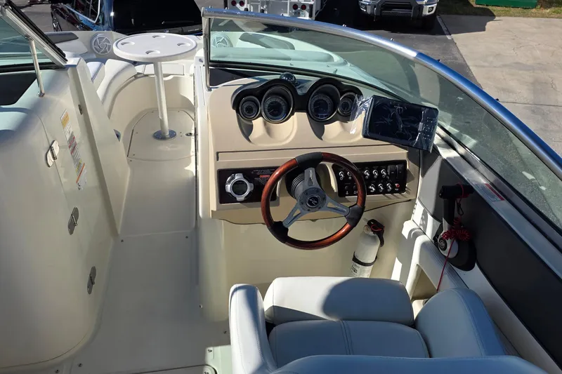Slide: The Image of 2010 Sea Ray 260 Sundeck cockpit with steering wheel, gauges, and seating. - 21