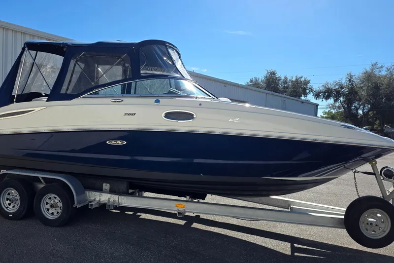 Slide: The Image of 2010 Sea Ray 260 Sundeck boat on trailer, featuring sleek design and navy blue hull. - 30
