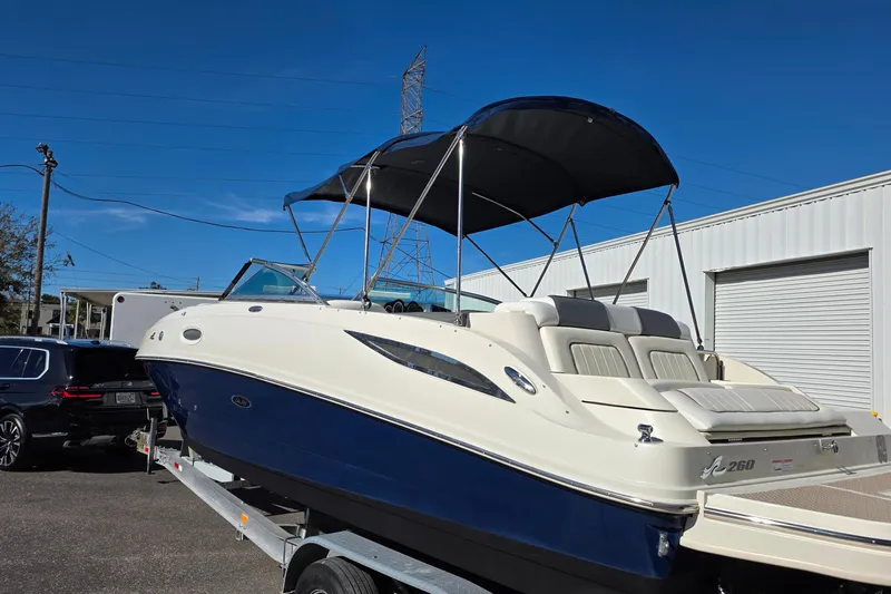 Slide: The Image of 2010 Sea Ray 260 Sundeck boat on trailer, featuring a sleek design and canopy. - 35