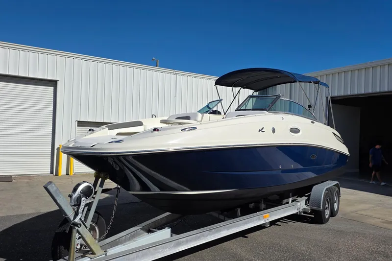 Slide: The Image of 2010 Sea Ray 260 Sundeck boat on trailer, parked outside a warehouse. - 36