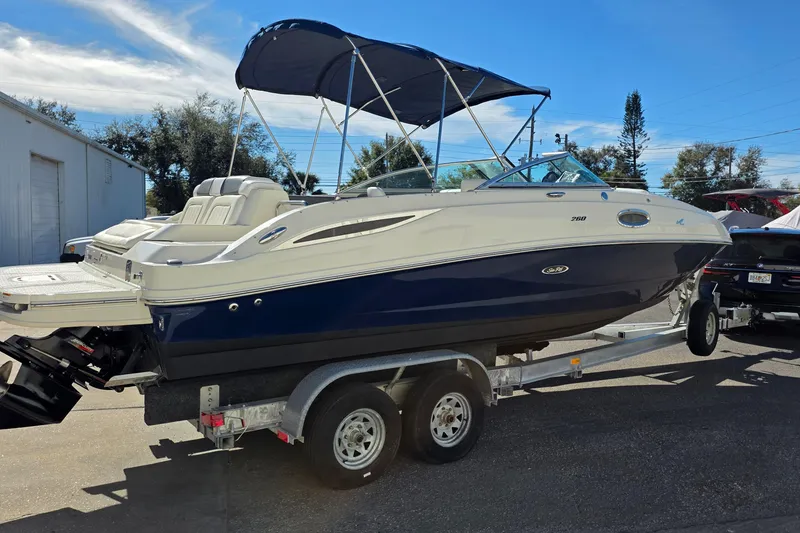 Slide: The Image of 2010 Sea Ray 260 Sundeck boat on trailer, featuring blue and white exterior with canopy. - 38