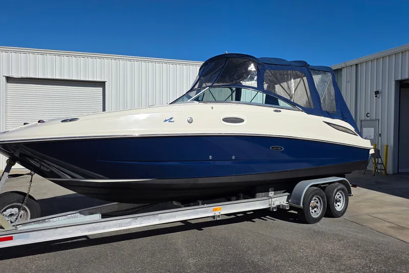 Slide: The Image of 2010 Sea Ray 260 Sundeck boat on trailer, parked outside a warehouse. - 4