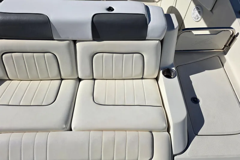 Slide: The Image of 2010 Sea Ray 260 Sundeck boat interior with white cushioned seating and cup holder. - 50