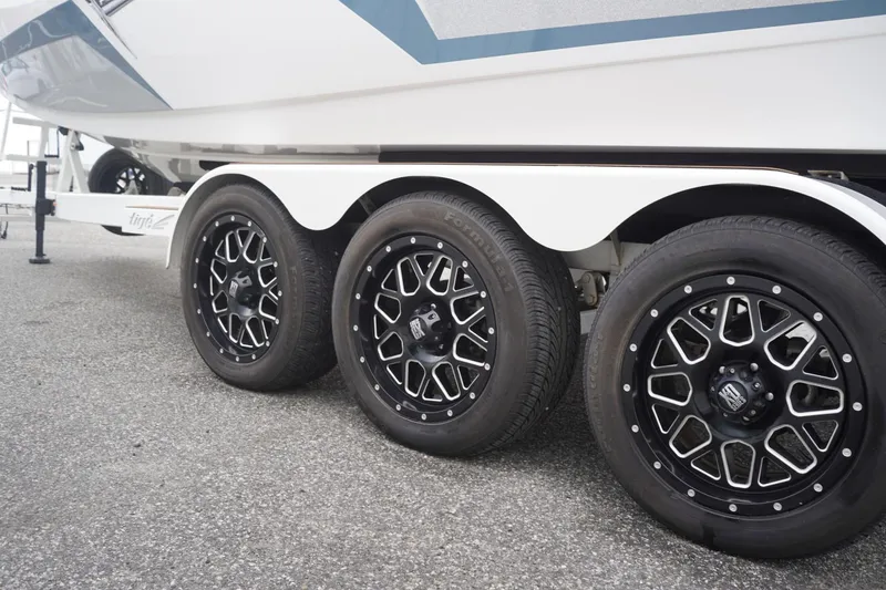 Slide: The Image of 2023 Tigé 24RZX boat trailer with stylish black alloy wheels. - 100