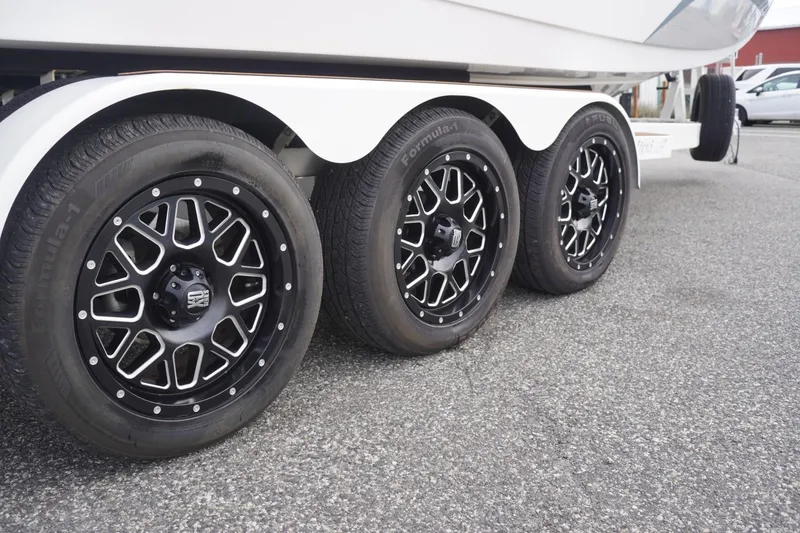 Slide: The Image of Trailer wheels of 2023 Tigé 24RZX boat on asphalt surface. - 101