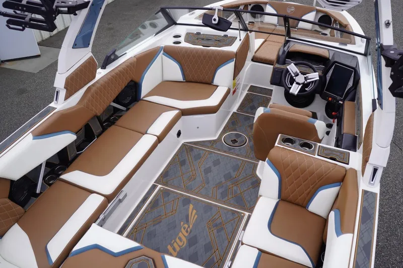 Slide: The Image of 2023 Tigé 24RZX boat interior with luxurious brown and white seating, modern dashboard. - 108