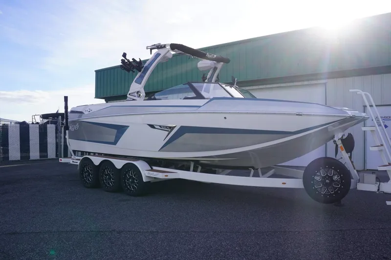 Slide: The Image of 2023 Tigé 24RZX boat on trailer, parked outdoors, showcasing sleek design and modern features. - 3