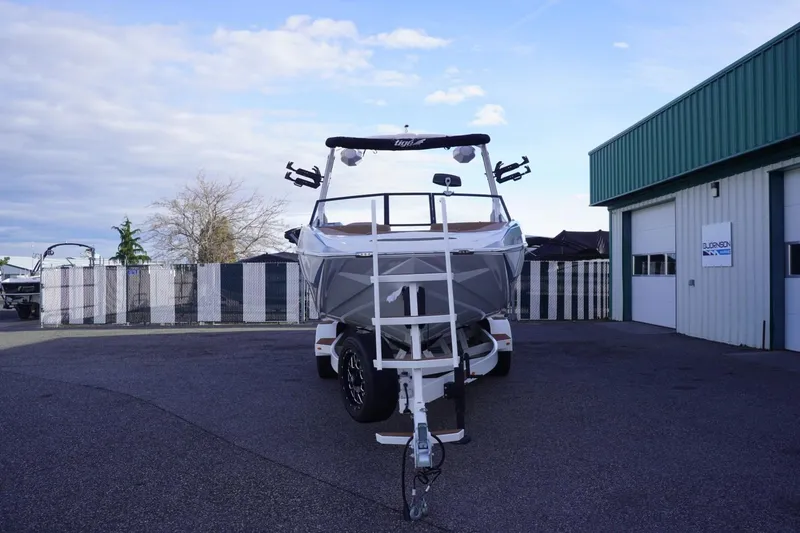 Slide: The Image of 2023 Tigé 24RZX boat on trailer outside a green building. - 4