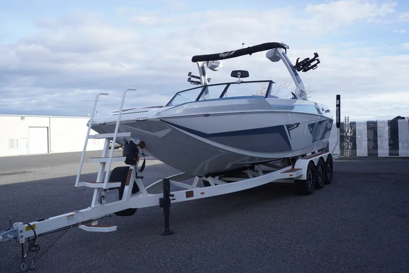 Slide: The Image of 2023 Tigé 24RZX boat on trailer, parked outdoors under cloudy sky. - 5