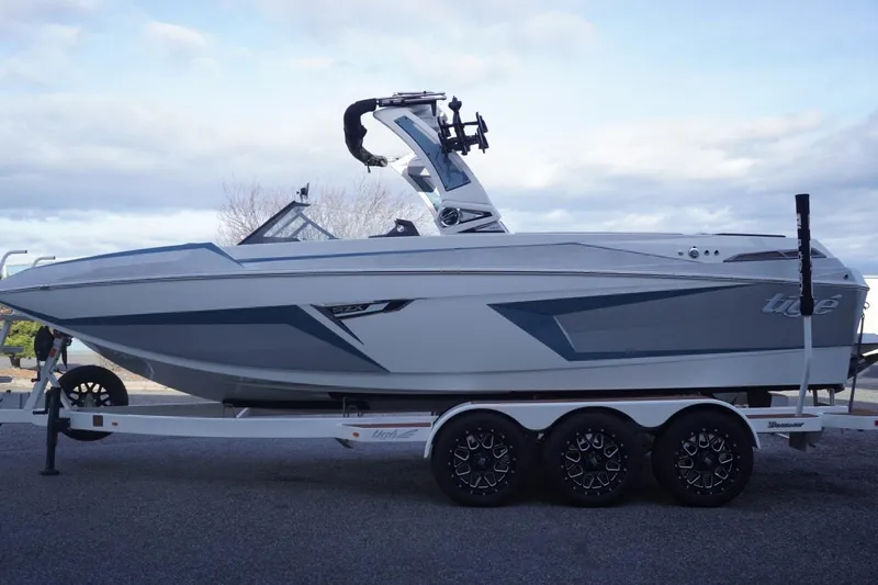 Slide: The Image of 2023 Tigé 24RZX boat on trailer, sleek design, overcast sky background. - 6