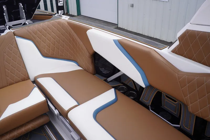 Slide: The Image of 2023 Tigé 24RZX boat interior with brown, white, and blue quilted seating. - 60