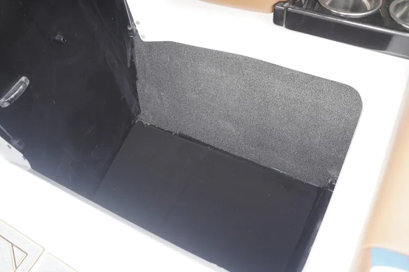 Slide: The Image of 2023 Tigé 24RZX boat storage compartment with black and gray interior. - 65