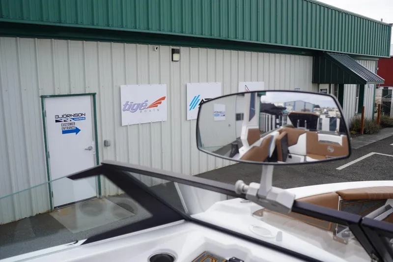 Slide: The Image of 2023 Tigé 24RZX boat at dealership entrance with reflection in rearview mirror. - 76