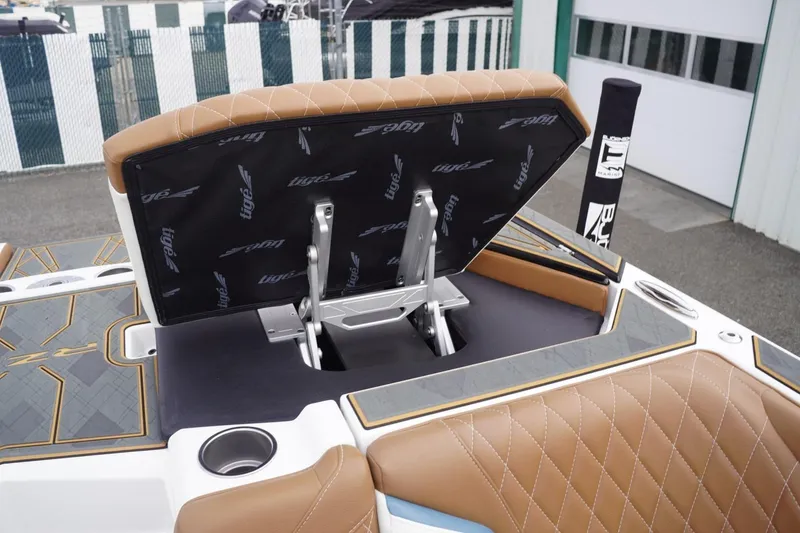 Slide: The Image of 2023 Tigé 24RZX boat with open storage compartment and brown quilted seating. - 77